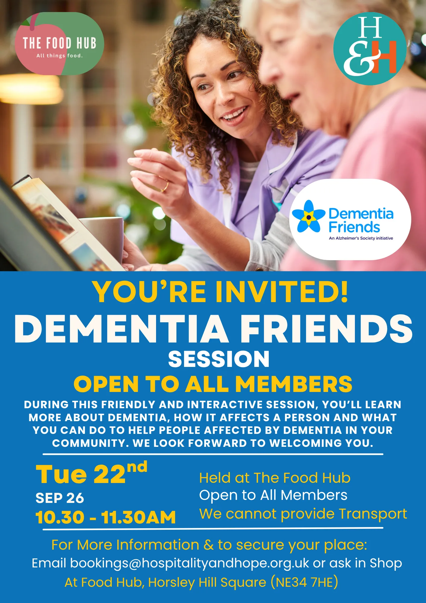 Two women discuss a tablet on a colorful event poster for a Dementia Friends session at The Food Hub, with sponsor logos visible on the page.