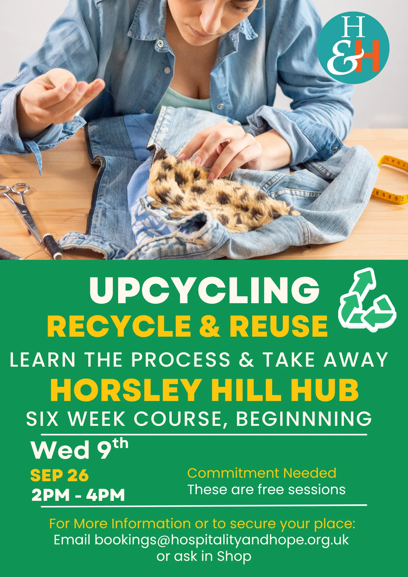 Person sewing denim and leopard‑print fabric on a wooden table; scissors and measuring tape nearby, with a teal HS&H logo in the corner and a green poster about upcycling and reuse in the foreground.